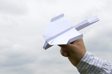 Menschliche Hand hält ein Papierflugzeug - AWDF00025