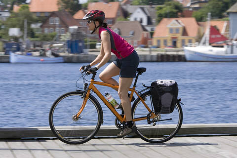 Dänemark, Syddanmark, Sonderborg, Mountainbikerin fährt über die Seebrücke, lizenzfreies Stockfoto