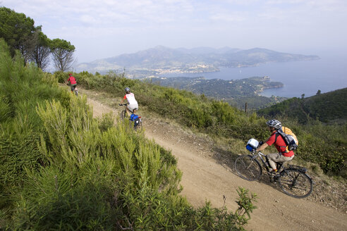 Italien, Toskana, Elba, Mountainbiker fahren über den Küstenpfad - DSF00158