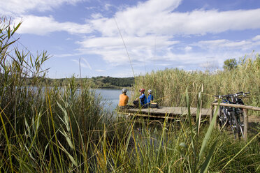 Italy, Tuscany, Lago dell'Accesa, Mountainbikers taking a break on the lakefront - DSF00144