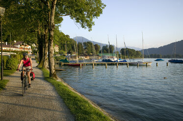 Deutschland, Bayern, Tegernsee, Frau beim Mountainbiking am See - DSF00137