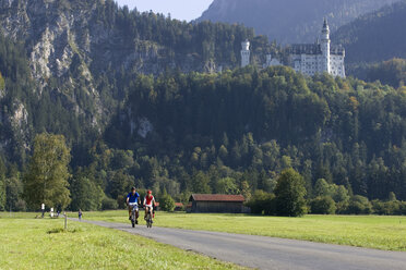 Germany, Bavaria, Neuschwanstein Castle, Couple mountain biking - DSF00115