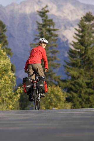 Österreich, Tirol, Ahornboden, Mountainbiker fahren über Autobahn, lizenzfreies Stockfoto