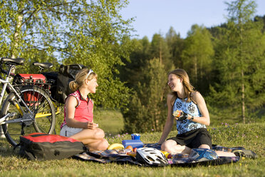 Deutschland, Bayern, Mittenwald, Zwei Frauen mit Mountainbikes beim Picknick - DSF00050