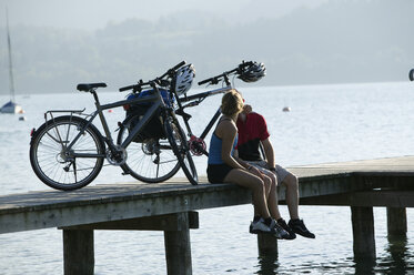 Deutschland, Bayern, Pärchen mit Mountainbikes macht Pause am Steg - DSF00015