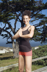 Young woman exercising yoga, hands together - ABF00449