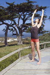 Junge Frau übt Yoga, Arme ausgestreckt - ABF00442