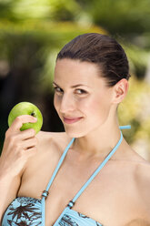Junge Frau im Bikini mit Apfel in der Hand, Porträt, Nahaufnahme - ABF00433