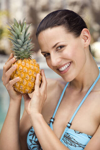 Junge Frau im Bikini mit Ananas, Porträt, lizenzfreies Stockfoto