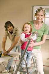 Family, Baby girl (1-2) on step ladder, man preparing wallpaper - WESTF09181