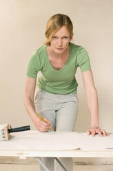 Young woman renovating, preparing wallpaper, portrait - WESTF09172