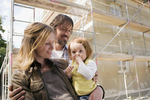 Young family in front of New Home Under Construction - WESTF09135