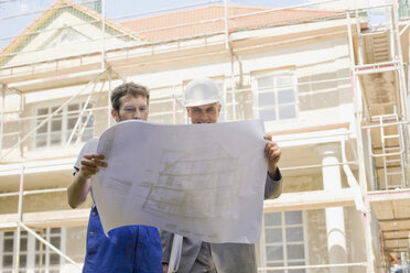 Architect and Construction worker looking at construction plan - WESTF09125