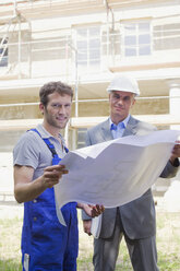 Architect and Construction worker holding construction plan - WESTF09124