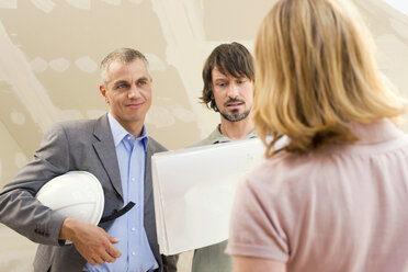 Architect discussing construction plan with young couple - WESTF09096