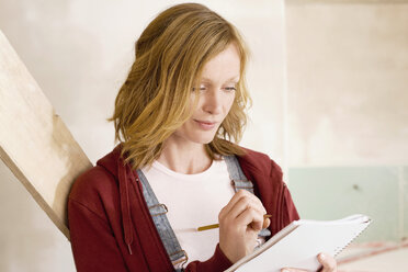 Young woman writing notes, portrait - WESTF09034