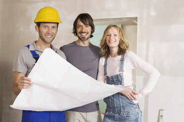 Junges Paar und Bauarbeiter mit Bauplan, lächelnd, Porträt - WESTF09032