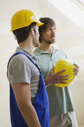 Two men with hard hats at construction site - WESTF09001