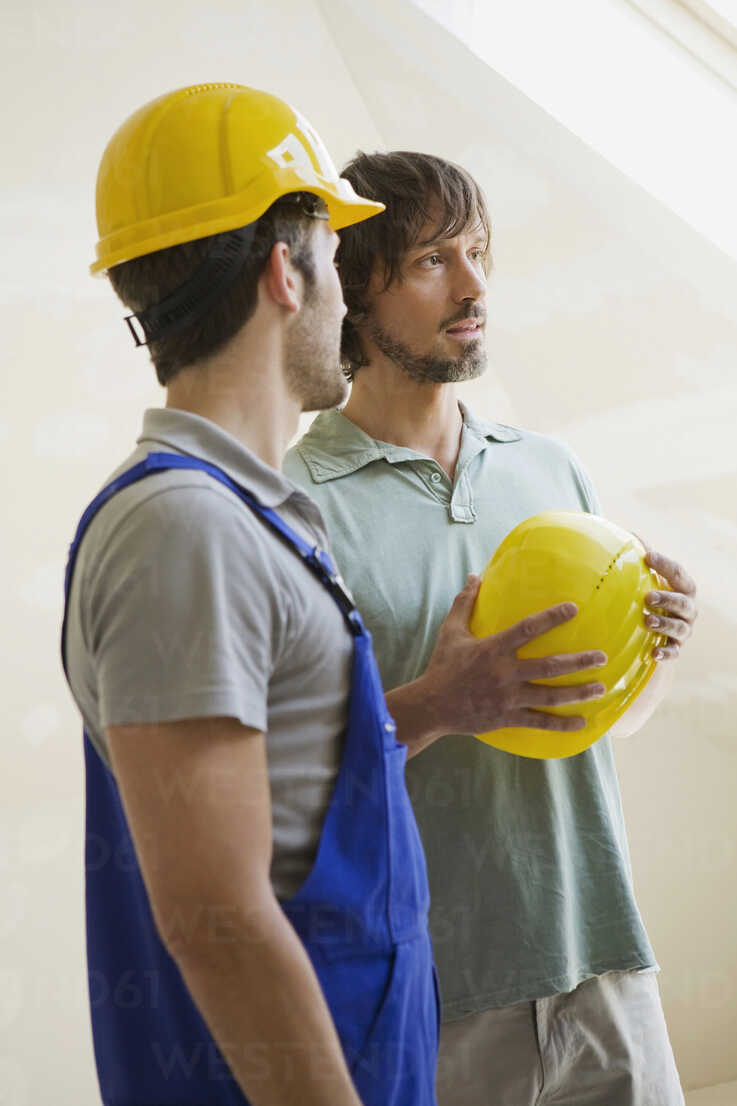 Two men with hard hats at construction site stock photo