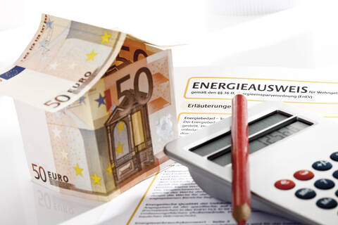 Haus aus Euro-Scheinen, Taschenrechner und Energieausweis, Nahaufnahme, lizenzfreies Stockfoto