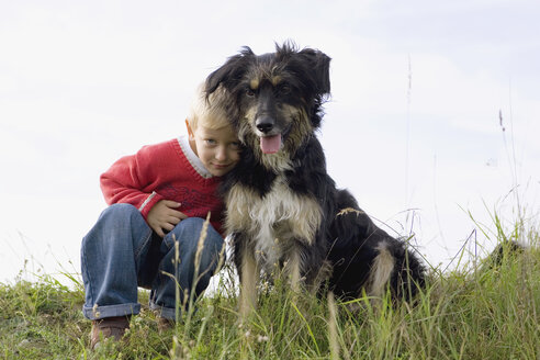 Little boy (3-4) playing with dog - SMOF00167