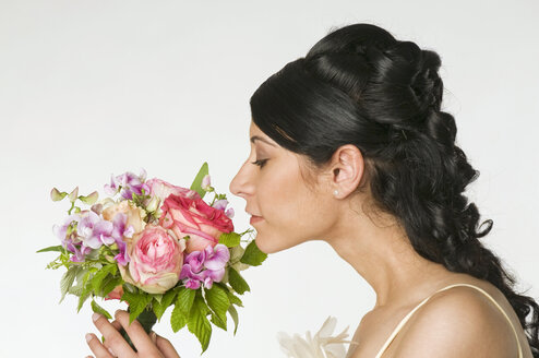 Junge Braut riecht an Blumen, Seitenansicht, Nahaufnahme - NHF00843