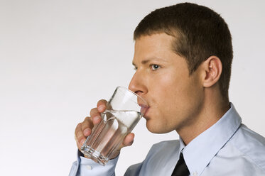 Geschäftsmann trinkt ein Glas Wasser - NHF00825