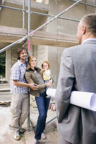 Architekt und junge Familie auf der Baustelle, lizenzfreies Stockfoto