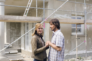 Junges Paar vor einem im Bau befindlichen Haus - WESTF09133