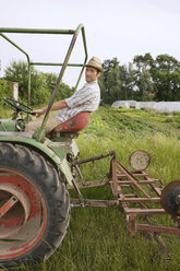 Landwirt auf Traktor pflügt Feld - BMF00500