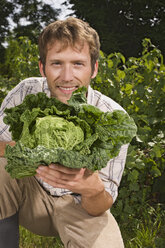 Man holding cabbage, portrait - BMF00462