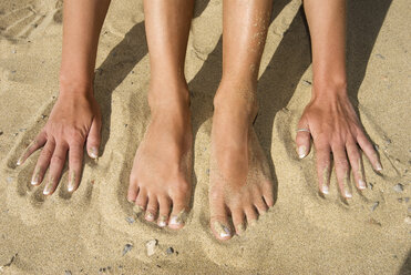 Spain, Lanzarote, Feet and hands on sand, elevated view - UMF00223