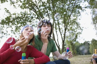 Deutschland, Junges Paar beim Blasen von Seifenblasen - WESTF09501