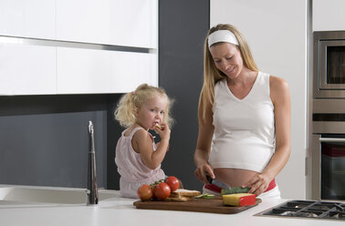 Pregnant mother and daughter (3-4) in the kitchen - WESTF10067