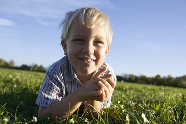 Kleiner Junge (2-3 Jahre) auf der Wiese liegend, lächelnd, Porträt - SMO00279