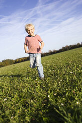 Little boy (4-5) running across meadow - SMO00267