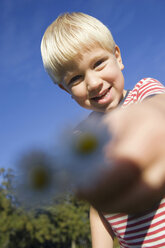 Little boy (4-5) holding daisies, low angle view - SMO00264