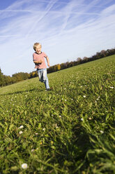 Little boy (4-5) running across meadow - SMO00263