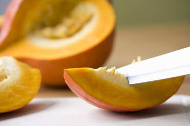 Knife slicing Hokkaido pumpkin, close-up - MAEF01179