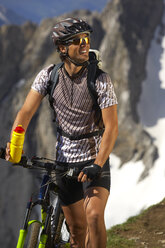 Germany, Bavaria, Karwendel, Man with mountain bike and water bottle - MRF01094