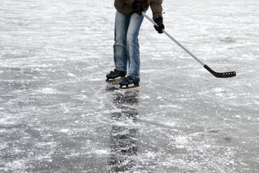 Person spielt Eishockey auf gefrorenem See - AWDF00291