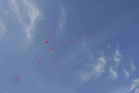 Rote herzförmige Luftballons am Himmel, lizenzfreies Stockfoto