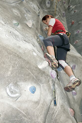 Young woman on indoor climbing wall, low angle view - AWDF00164