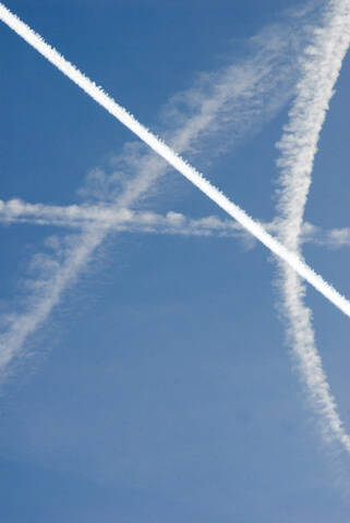 Condensation trails in sky, low angle view stock photo