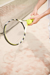 Tennisspieler hält zwei Tennisbälle - UKF00165