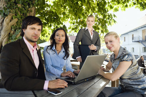 Germany, Bavaria, Upper Bavaria, Business people using laptop in beer garden - WESTF09775