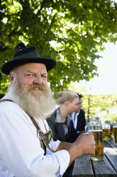 Deutschland, Bayern, Oberbayern, Mann in Tracht hält Bierkrug, Porträt - WESTF09729