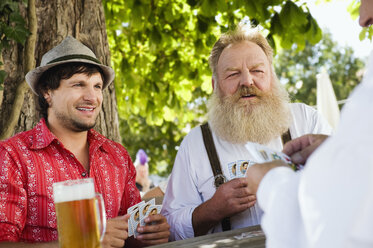 Germany, Bavaria, Upper Bavaria, Men playing cards in beer garden - WESTF09643
