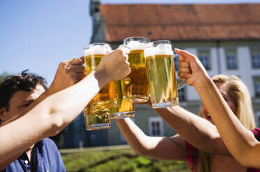 Deutschland, Bayern, Oberbayern, Fröhliche Menschen stoßen im Biergarten aufeinander an - WESTF09589