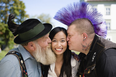 Germany, Bavaria, Upper Bavaria, Two men kissing Asian woman on cheek, portrait - WESTF09552